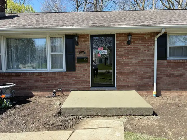 Brick ranch house with a bare concrete front step before the portico was built